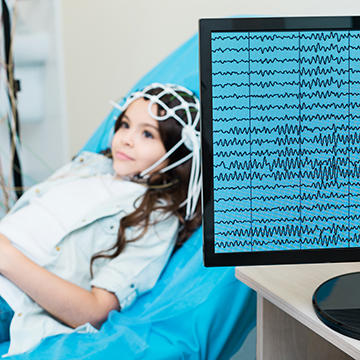 child with wires on head for test and digital monitor