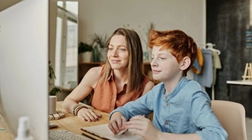 woman and young boy looking at computer together